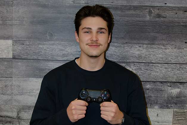 Headshot of Alex D'Orazio holding gaming controller with his signature